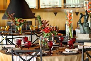 sophisticated table arrangements with red jackfruit glasses photo