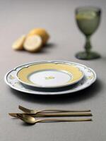 yellow plates with golden cutlery on the table photo