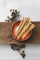 bronze and wooden tray with snacks, pepper and flowers photo