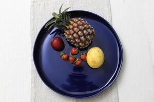 blue ceramic plate with fruits seen from above photo
