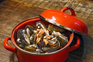 mussels in vinaigrette sauce in red pan photo