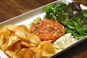 steak tartar with leaf salad and french fries photo