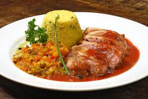 roast duck with sauce and Moroccan couscous on plate photo