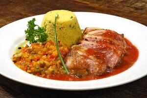 roast duck with sauce and Moroccan couscous on plate photo