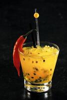 Passion fruit caipirinha with red pepper in glass photo