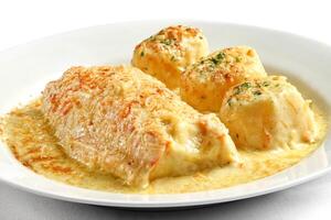 Whiting fish with cheese sauce and potatoes au gratin photo