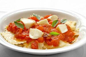 cheese ravioli with fresh tomato sauce and mozzarella photo