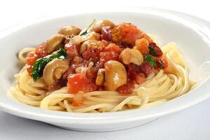 Mediterranean spaghetti with chopped tomatoes, mushrooms, onions and basil photo