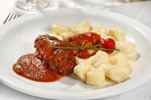 Ñoquis con braciola en tomate salsa foto