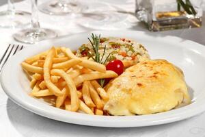 Chicken fillet with cheese and fries photo