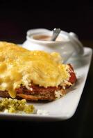 open pastrami sandwich on plate with gratin cheese and vinaigrette sauce photo