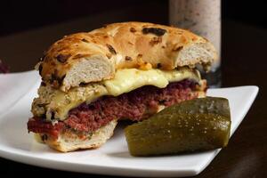 Pastrami sandwich with cabbage, cheese, sauce, pickles on ciabatta bread photo