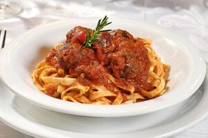 Fettuccine y polpetona en tomate salsa foto