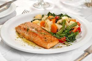 Grilled salmon with vegetables on plate photo