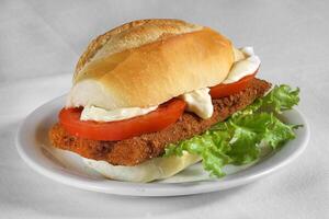 Milanese steak sandwich with tomato, lettuce and mayonnaise on French bread photo