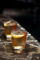 Godfather, classic drink with scotch whiskey, amaretto and bitters in a glass with ice photo