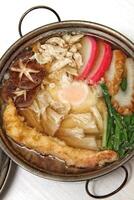 Nabeyaki udon, Japanese soup with cured fish, seaweed, sake, egg and shitake photo