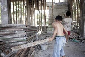 Poor children at the construction site were forced to work. Concept against child labor. The oppression or intimidation of forced labor among children. Human trafficking. photo