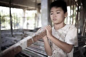 Poor children at the construction site were forced to work. Concept against child labor. The oppression or intimidation of forced labor among children. Human trafficking. photo