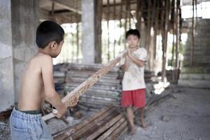 Poor children at the construction site were forced to work. Concept against child labor. The oppression or intimidation of forced labor among children. Human trafficking. photo