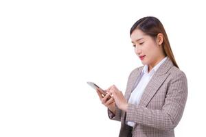 una trabajadora asiática con traje formal y camisa blanca está haciendo una llamada telefónica para verificar la información. foto