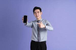 retrato de asiático masculino empresario posando en púrpura antecedentes foto
