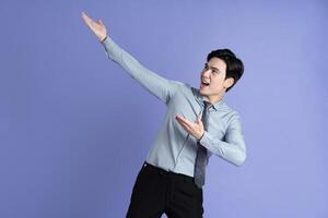 retrato de asiático masculino empresario posando en púrpura antecedentes foto