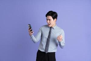 Portrait of Asian male businessman posing on purple background photo