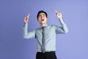 retrato de asiático masculino empresario posando en púrpura antecedentes foto