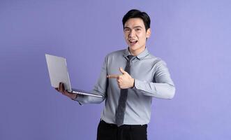 Portrait of Asian male businessman posing on purple background photo