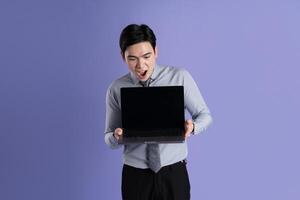 Portrait of Asian male businessman posing on purple background photo