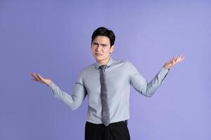 Portrait of Asian male businessman posing on purple background photo