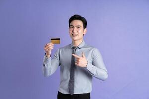 Portrait of Asian male businessman posing on purple background photo