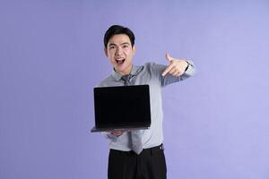 Portrait of Asian male businessman posing on purple background photo