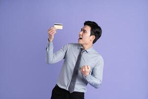 Portrait of Asian male businessman posing on purple background photo