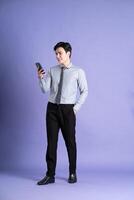 retrato de asiático masculino empresario en pie y posando en púrpura antecedentes foto