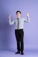 retrato de asiático masculino empresario en pie y posando en púrpura antecedentes foto