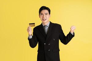 retrato de asiático masculino empresario. vistiendo un traje y posando en un amarillo antecedentes foto