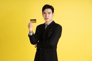 Portrait of Asian male businessman. wearing a suit and posing on a yellow background photo