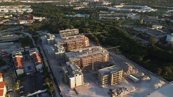 fuco Visualizza di grande costruzione luogo per uno Di Più nuovo Hotel complesso con grande panoramico su tramonto collocato lungo riva del mare nel punta cana, domenicano repubblica. novale. Torre gru, scavatrice e sabbia. video