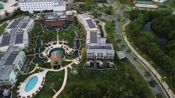 Aerial view of Secrets Royal Beach Punta Cana is tropical hotel that boasts solar panels on its roof, along with picturesque pool and stunning grounds. Cinematic flight forward video