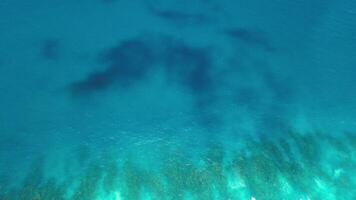 Fluid art. Area view of great Barrier Reef landscape aerial of colorful coral and turquoise ocean, bright glow of Atlantic Ocean, gradient of blue, shadows from clouds near Dominican Republic. video