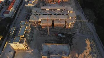 Impressive aerial view unfolds of construction site nestled within vibrant tourist area overlooking ocean in Punta Cana, Dominican Republic. Dominating scene is towering crane video