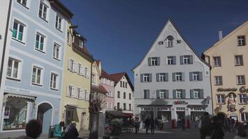 Mars 31, 2024. fussen, Tyskland. altstadt, fuessen, bayern, tyskland. gammal stad i solig väder med människor vilar, kaféer och restauranger. historisk gammal bavarian byggnader på fussen. video