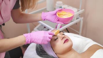 ung kvinna får skönhet ansiktsbehandling injektioner i salong. ansikte åldrande, föryngring och hydratisering förfaranden. estetisk kosmetologi. video