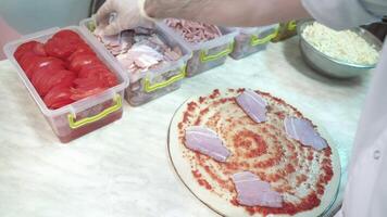 vaardig chef voorbereidingen treffen een pizza. handen van Mens in actie video