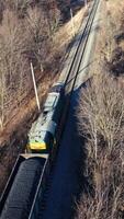 Aerial view of the forest in winter. Aerial view of a road in the middle of the forest Vertical video