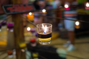 Closeup of burning candles in metal grid. photo