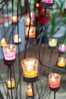 Closeup of burning candles in metal grid. photo