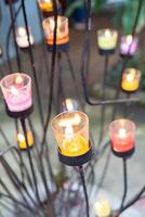 Closeup of burning candles in metal grid. photo